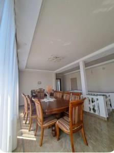 a dining room with a wooden table and chairs at SWEET HOUSE 470 in K'obulet'i