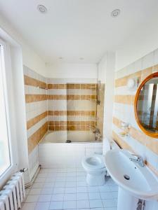 a bathroom with a tub and a toilet and a sink at Noisy Home - 10 pers - Paris in Noisy-le-Grand