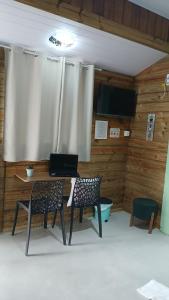 a room with a table and two chairs and a laptop at Suite 66 privativa, 11km da vila Germânica in Blumenau