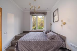 a bedroom with a bed and a window at Forest view front line apartment on Dzintaru avenue in Jūrmala