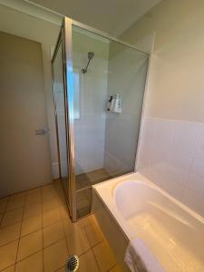 un baño con ducha y bañera en Comfy and relaxing stay - Rest Easy Mudgee Cottage, en Mudgee