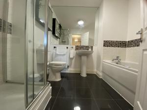 Un baño con inodoro, lavabo y bañera. en Modern 5-Bedroom House in Maidenhead, en Maidenhead 22 fotos más