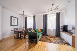 a living room with a green couch and a table at Forest view front line apartment on Dzintaru avenue in Jūrmala