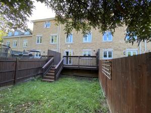 una valla de madera frente a un edificio en Modern 5-Bedroom House in Maidenhead, en Maidenhead