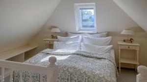 a bedroom with a white bed with pillows and a window at Ferienwohnung Heefwai 2 "W4" in Morsum