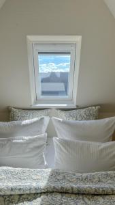 a bedroom with two beds with pillows and a window at Ferienwohnung Heefwai 2 "W4" in Morsum +15 photos