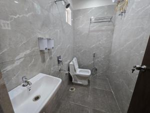 un baño con lavabo e inodoro en Hotel EVA, en Gundipet