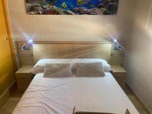 a bedroom with a bed with two pillows on it at Moderno adosado junto al POLIDEPORTIVO de NUCIA in Polop