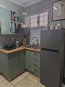 a kitchen with a refrigerator and a sink at Nouvelle Vie Self-catering Accommodation in Reebok