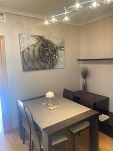 a dining room table with chairs and a painting on the wall at Moderno adosado junto al POLIDEPORTIVO de NUCIA in Polop