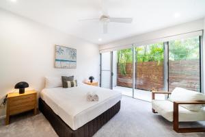 una camera da letto con un letto grande e una sedia di Doorilla Coastal Retreat a Mission Beach Altre 24 foto