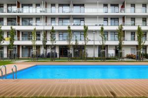 an apartment building with a swimming pool in front of it at Premium & Elegance Apartments with Pool by Noclegi Renters in Sianozety