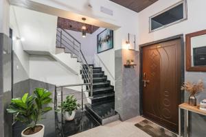 a hallway with stairs and a wooden door at FabExpress Milan Palace in Ayodhya