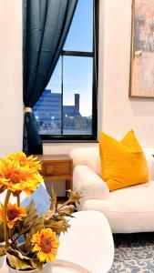 Una sala de estar con un sofá blanco y una ventana. en Downtown 4B2B Apt, Walk to PPAC & Convention Center, en Providence