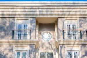 a building with two balconies and a clock on it at The Passport Hotel in Assagao