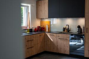a kitchen with wooden cabinets and black counter tops at Spacious 2 bedroom apartment in Engelberg