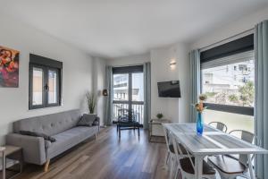 ein Wohnzimmer mit Sofa und Tisch in der Unterkunft Vinos & Vinilos by Ĥ in Ayamonte