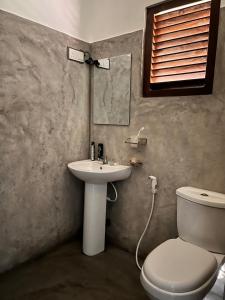 a bathroom with a toilet and a sink at Melon Guest - Weligama in Weligama