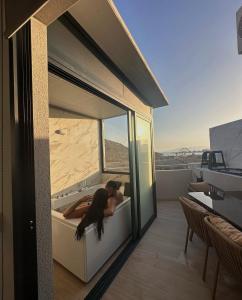 una donna sdraiata su una vasca da bagno su un balcone di Aptos Laguna Premium a Puerto de Mazarrón