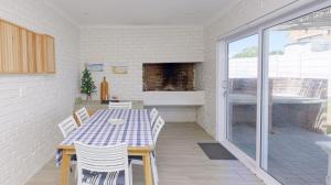 a dining room with a table and chairs on a patio at Ondermaat in Agulhas