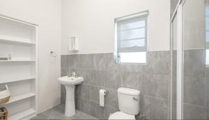 a bathroom with a toilet and a sink at Ondermaat in Agulhas +11 photos