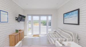a living room with a couch and a tv at Ondermaat in Agulhas