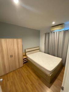 a small bedroom with a bed and a cabinet at Town House in Ban Ket Ho