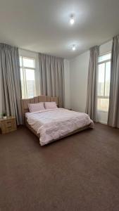 a bedroom with a large bed in a room with windows at Khalifa A Home Stay Suite Room in Abu Dhabi