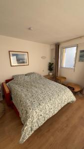 a bedroom with a bed and two windows at Evasion en bord de Mer in Quiberon