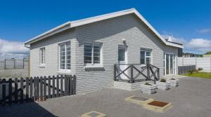 a small house with a fence in front of it at Ondermaat in Agulhas