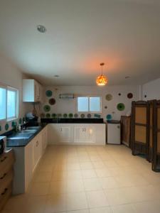 a large kitchen with white cabinets and black counter tops at Town House in Ban Ket Ho