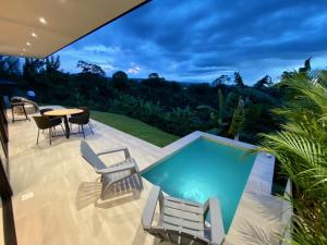 a patio with a pool and chairs and a table at Casa MOARA in Pereira
