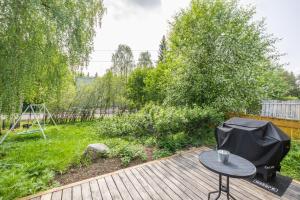 une terrasse en bois avec une table et une aire de jeux dans l'établissement Santa's Aurora Wonderland, à Rovaniemi