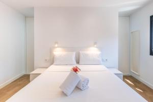 a white bedroom with a large white bed with towels on it at Modern Balcony House - Solarium Terrace - Parking in Arafo