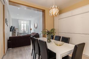 una sala da pranzo con tavolo, sedie e divano di Waou Apartamentos en Sol Confort 9 a Madrid
