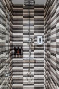 una doccia con piastrelle a righe bianche e nere in bagno di Waou Apartamentos en Sol Confort 9 a Madrid Altre 23 foto