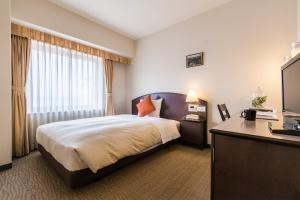 a hotel room with a bed and a desk at Hotel Resol Hakodate in Hakodate