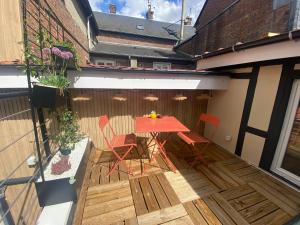 a wooden deck with a table and chairs on it at Suite Magnolia in Évreux