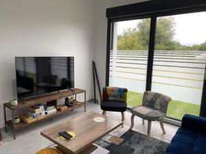 a living room with a tv and a couch and a table at Gite de l'etoile in Rocroi