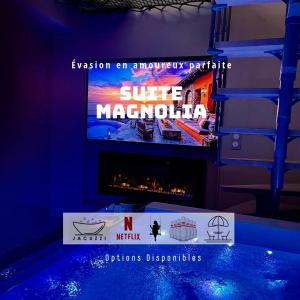 a tv screen with a sign in a room with a fireplace at Suite Magnolia in Évreux