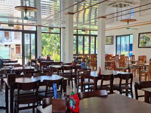 a dining room with tables and chairs and windows at Vista Tam Coc Hotel in Vũ Lâm