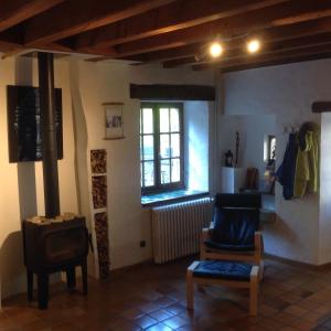a living room with a wood stove and a chair at CARDABELLE maison authentique à louer in Millau