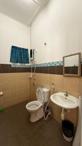 a bathroom with a toilet and a sink at RABIA Homestay in Tawau