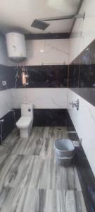 un baño con inodoro y lavabo en Alif inn, en Srinagar