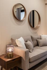 a living room with a couch and two mirrors at Waou Essence II Lavapiés - Alquiler Corta Duración in Madrid