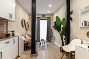 a kitchen with white cabinets and a living room at Waou Essence II Lavapiés - Alquiler Corta Duración in Madrid