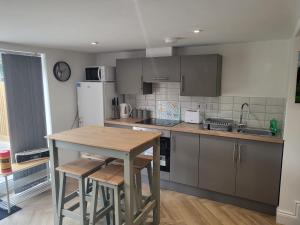 a kitchen with a wooden table and a counter top at Cwtch on The meadow in Abergavenny
