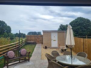 a patio with a table and an umbrella at Cwtch on The meadow in Abergavenny