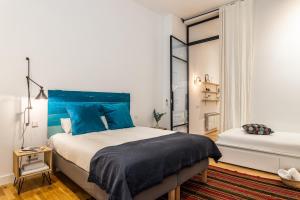 a bedroom with a large bed with blue pillows at Waou Sol V - Alquiler de Corta Duración in Madrid