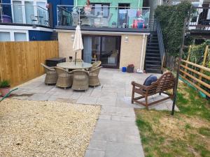 a patio with a table and chairs and an umbrella at Cwtch on The meadow in Abergavenny